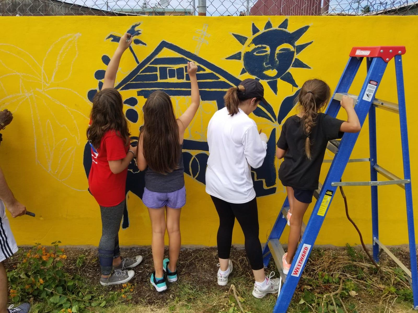  AD&amp;V team members and family painting mural 