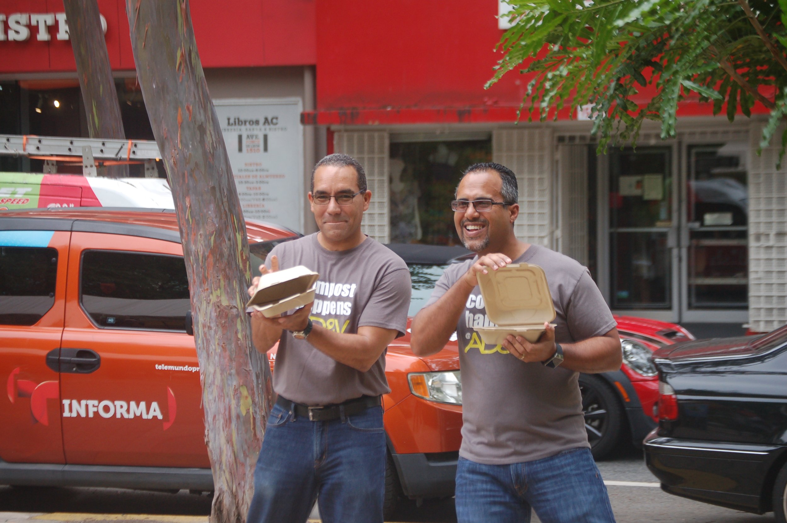  AD&amp;V team members posing for picture with compostable food containers 
