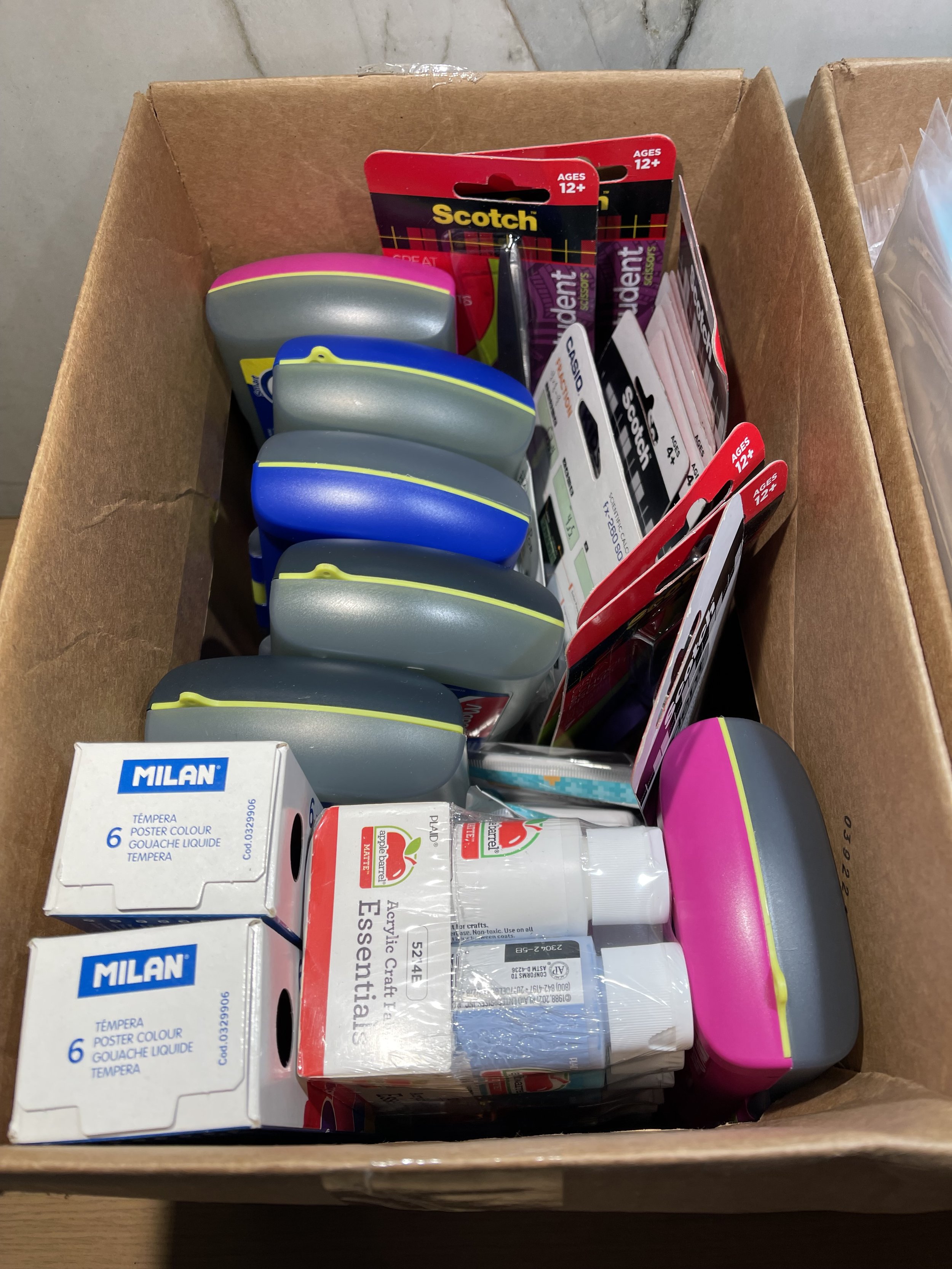  Closeup of school supplies inside of a box. 