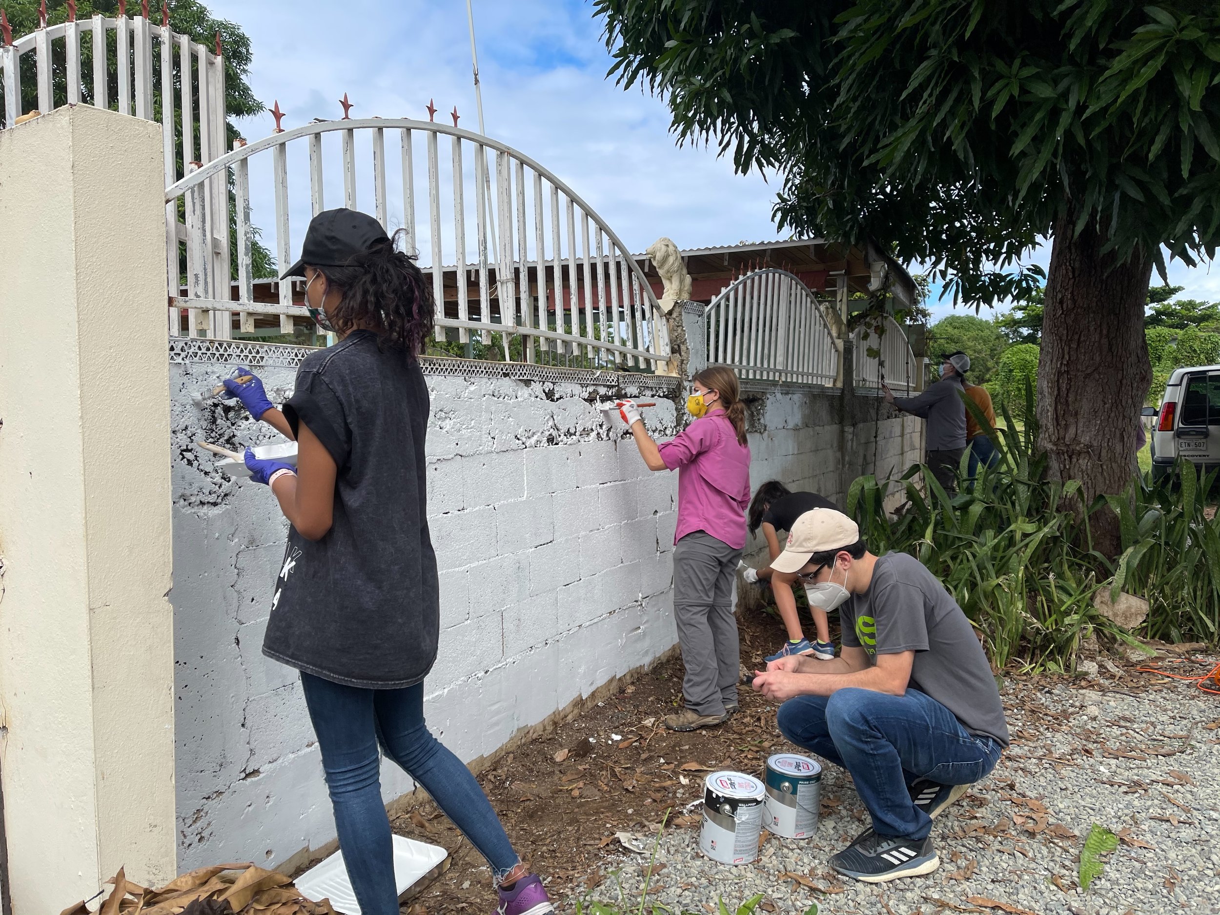  Volunteers painting exterior Vietnam Estudia walls 