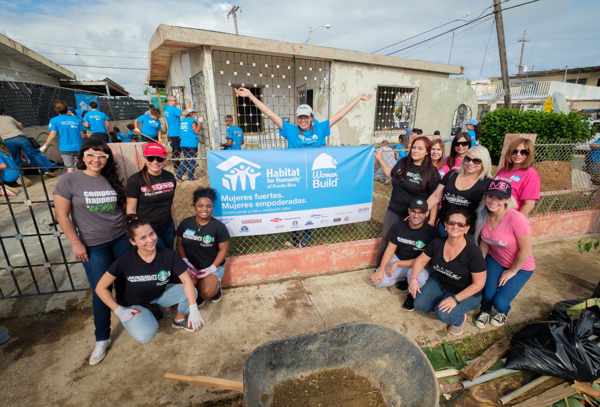  Volunteers posing for picture outside of home after reconstruction 